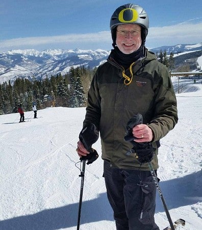 Jon Meyer, in a ski helmet with the UO "O", on the slopes